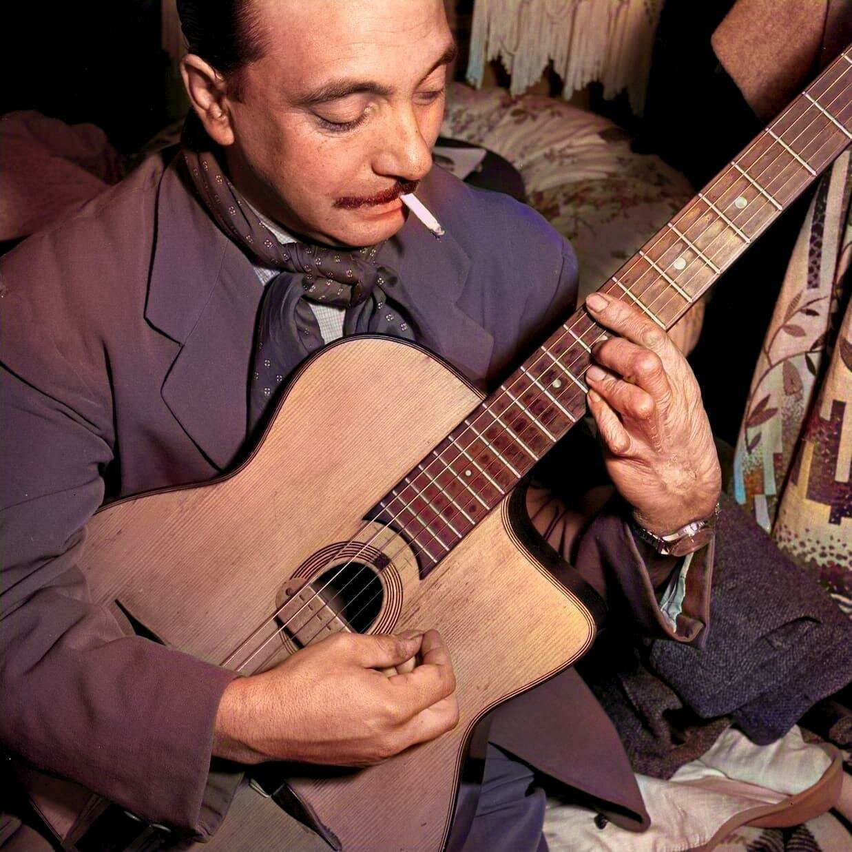 Django Reinhardt jouant de la guitare en 1946, une icône du jazz manouche.